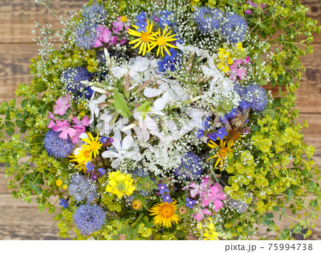 Bouquet of wildflowers on old wooden boards. Bouquet of wildflowers on old wooden boards. 75994738