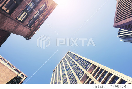Looking up at New York skyscrapers, color toned picture, USA. 75995249