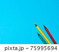 Green, Yellow and Red Pencils on Blue Background 75995694