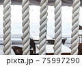 Closeup of strong string white ropes on background sea and deck. Abstract sailor marine backdrop. Textured twisted vertically fiber line 75997290