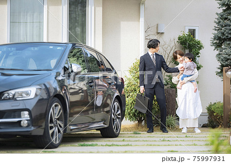 出勤する夫を見送り妻と赤ちゃん 75997931
