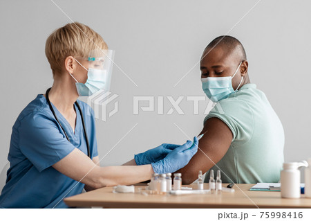 Doctor giving Covid-19 or flu antiviral vaccine to patient Doctor giving Covid-19 or flu antiviral vaccine to patient 75998416