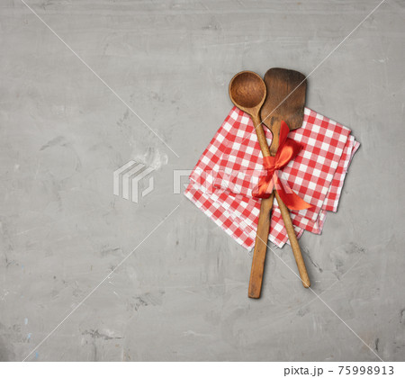 old spoon and spatula tied with red ribbon on a gray background 75998913