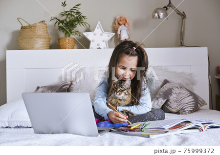 Distance learning online education. Schoolgirl with digital tablet laptop notebook and doing school 75999372
