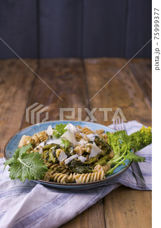 Cime di rapa pasta in a plate on with parmesan on a wooden table. Traditional food of the south of 75999377