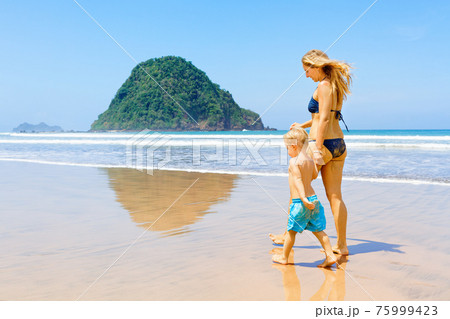 Happy family run by wide sand beach 75999423