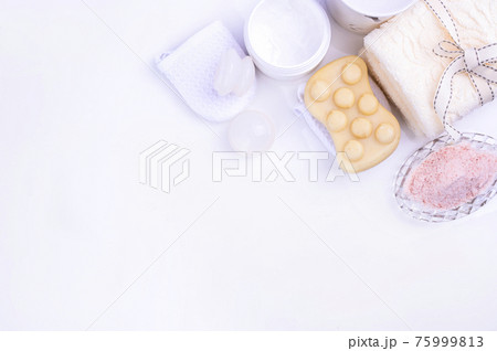 Spa relax and bath concept, sea salt, soap, with cosmetics and towels on a white background. A soft Spa relax and bath concept, sea salt, soap, with cosmetics and towels on a white background. A soft 75999813
