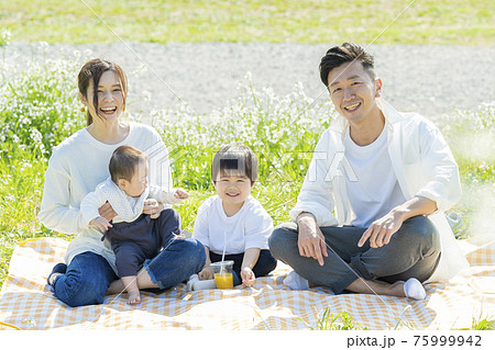 ピクニックで記念写真におさまる家族 75999942