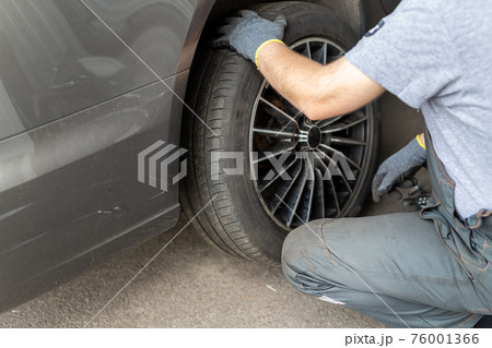 Car wheel repair shop outdoor ground . Seasonal winter tyre change at workshop. Vehicle tire repair, inspection and maintenance. Automotive garage for replace spare parts after failure breakdown 76001366