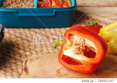 Half cut pepper on wooden table, close up 76002207