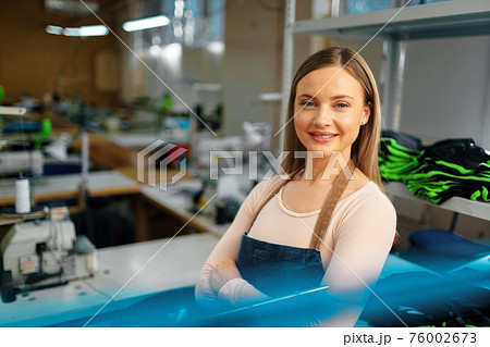 Portrait of a seamstress standing at working place and looking at camera 76002673