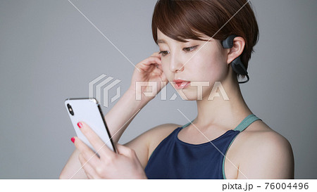 スマホで音楽を聴く女性 76004496