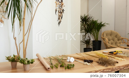 dried flowers and herbs on a table in a florist workshop 76007304
