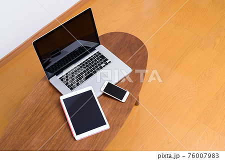小さいテーブルの上のパソコンとスマホとタブレット 76007983