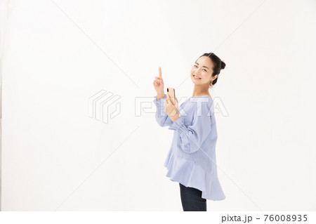 スマホを持つ女性　指差し 76008935