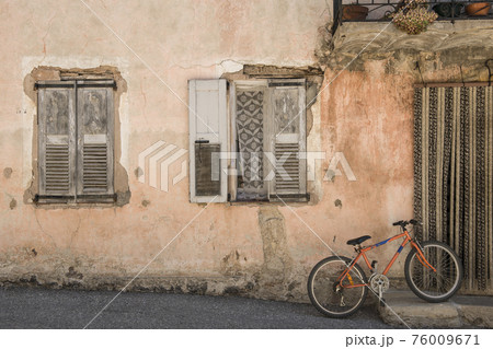 Old idyllic house with orange bike in front of it in a city in the Provence in France 76009671