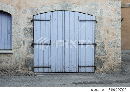 Closed large blue door in an old house in the Provence, France 76009702