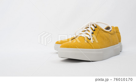 Side view of fashionable mustard-colored shoes. Sneakers on a white background. The shoe fabric is made from recycled textiles. Eco-friendly comfort. The concept of caring for the environment 76010170