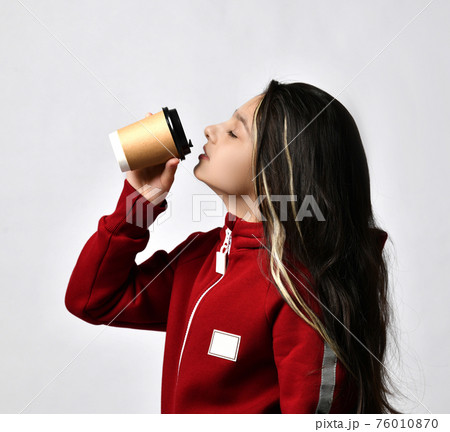 Caucasian preteen girl model in tracksuit drinking 76010870