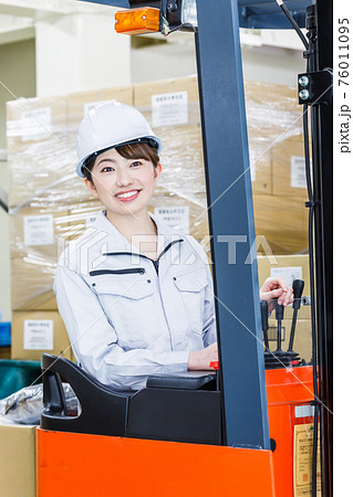 ヘルメットを被りフォークリフトを操作する女性 ヘルメットを被りフォークリフトを操作する女性 76011095
