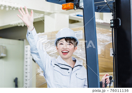 ヘルメットを被りフォークリフトを操作する女性 ヘルメットを被りフォークリフトを操作する女性 76011136
