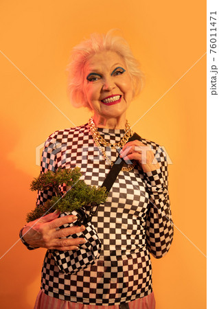 Woman keeps hands at her bag and looking directly at camera 76011471