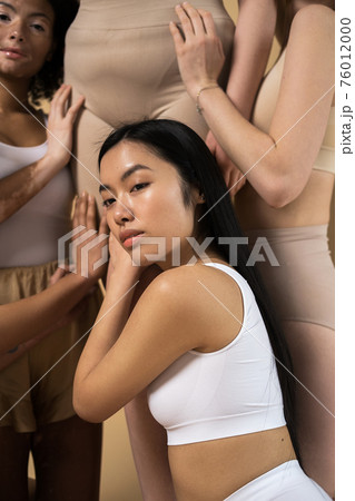 Long haired asian woman posing with her diverse girlfriends 76012000