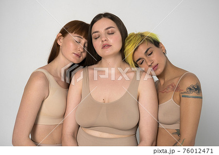 Three diverse girls posing with eyes closed at the studio 76012471