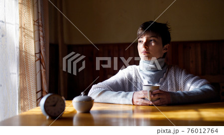 Poor sad small girl sitting at the table indoors at home, poverty concept. Poor sad small girl sitting at the table indoors at home, poverty concept. 76012764