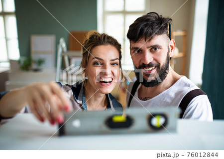 Mid adults couple witj leveler indoors at home, relocation and diy concept. Mid adults couple witj leveler indoors at home, relocation and diy concept. 76012844