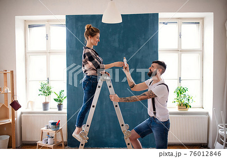 Mid adults couple changing light bulb indoors at home, relocation and diy concept. Mid adults couple changing light bulb indoors at home, relocation and diy concept. 76012846