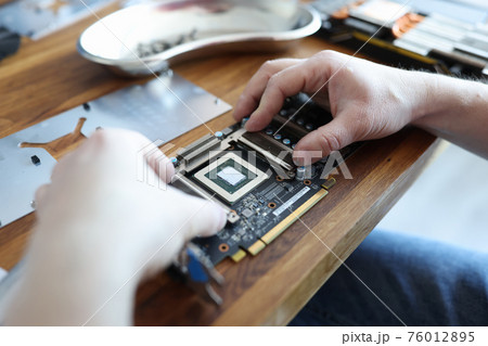 Master repairing video card in workshop closeup 76012895