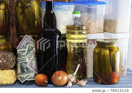 glass jar with paper dollars. against the background of products. Keeping the money. Investment. Financial crisis. Decline in the rate of growth of the dollar 76013110