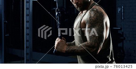 Incognito bodybuilder doing crossover exercise. 76013425