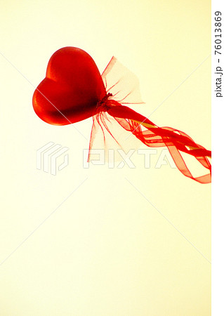 Red heart attached to a stick with a bow hanging 76013869