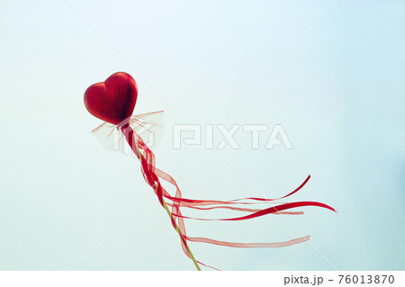 Red heart attached to a stick with a bow hanging 76013870