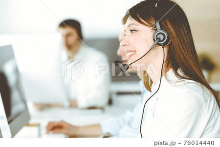 Group of diverse operators at work in call center. Beautiful asian woman sitting in headset at customer service office. Business concept 76014440