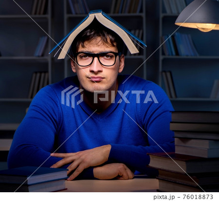 Student preparing for exams late at night in library Student preparing for exams late at night in library 76018873