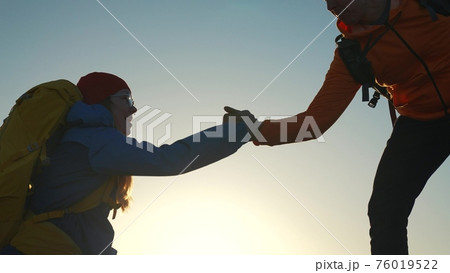 teamwork. help business travel silhouette concept. group team of tourists lends helping hand climb the cliffs mountains. teamwork people climbers climb adventure to top helping hand hardships path 76019522