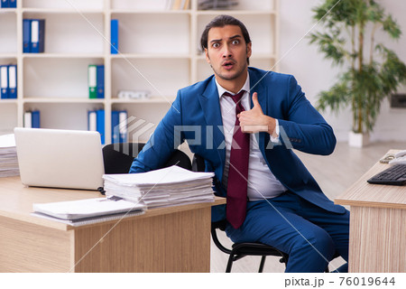 Young male employee in multitasking concept Young male employee in multitasking concept 76019644