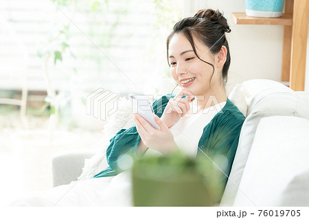 スマホを見る若い女性 76019705