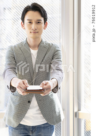 名刺を差し出す男性(正面) 名刺を差し出す男性(正面) 76019912