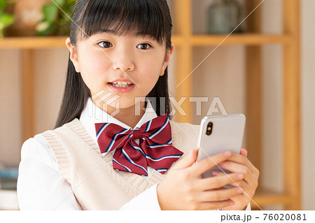 スマホを使う小学生の女の子の写真素材