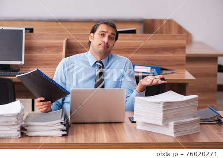 Young male employee unhappy with excessive work Young male employee unhappy with excessive work 76020271