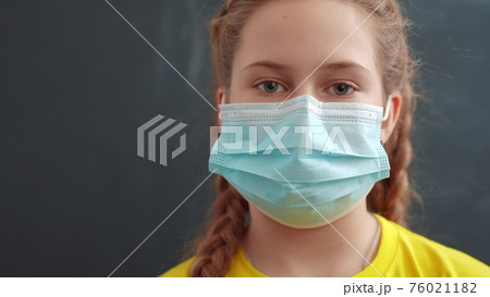 kid face in medical mask. pandemic coronavirus medicine concept. portrait of a face covid girl kid child in a protective mask into the coronavirus pandemic covid. Coronavirus protection 76021182
