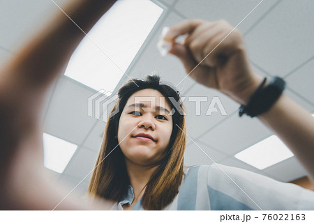Woman use eye drop, artificial tears to the eye 76022163