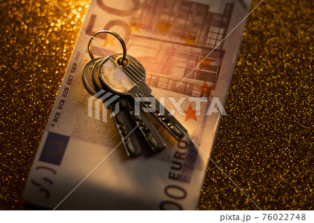 keys and money banknotes on golden background keys and money banknotes on golden background 76022748