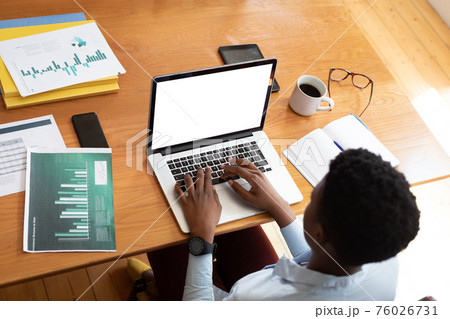 Overhead view of african american woman using laptop while working from home 76026731