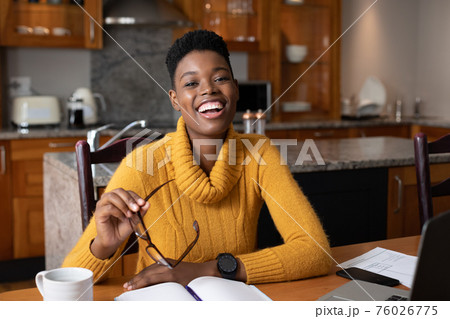 Portrait of african american woman smiling while working from home Portrait of african american woman smiling while working from home 76026775