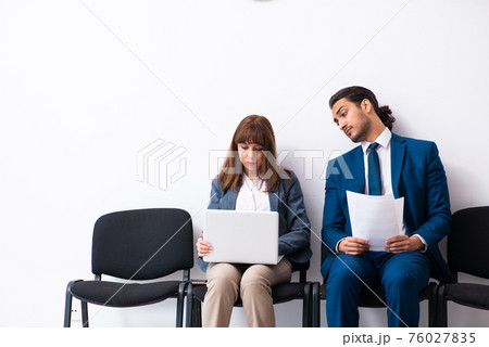 Young businessman and businesswoman waiting for an interview at 76027835